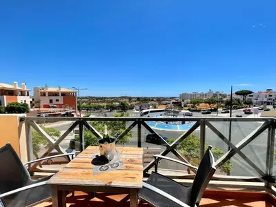 a wooden table on a balcony with a view of a city at Albufeira Modern 2 With Pool by Homing in Albufeira