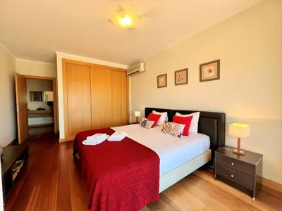 a bedroom with a large bed with a red blanket at Albufeira Modern 2 With Pool by Homing in Albufeira