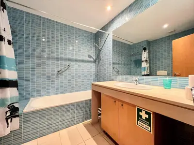 a bathroom with blue tiled walls and a tub and a sink at Albufeira Modern 2 With Pool by Homing in Albufeira