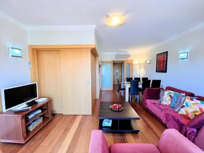 a living room with a purple couch and a tv at Albufeira Modern 2 With Pool by Homing in Albufeira