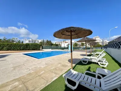 a couple of chairs and umbrellas next to a pool at Albufeira Modern 2 With Pool by Homing in Albufeira