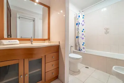 a bathroom with a sink and a toilet and a tub at Quarteira Beach - 2 D by HelloVacations in Loulé