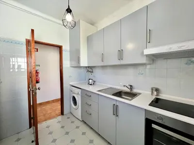 a white kitchen with a sink and a dishwasher at Albufeira Classic 2 by Homing in Albufeira