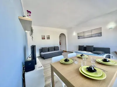 a living room with a dining table and a tv at Albufeira Classic 2 by Homing in Albufeira