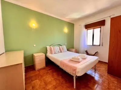 a bedroom with a bed with a green wall at Albufeira Classic 2 by Homing in Albufeira