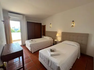 a hotel room with two beds and a window at Villa Dantas by amcf in Vilamoura