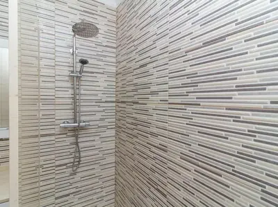a bathroom with a shower with a stone wall at Magnólia O House by Stay ici Algarve Holiday Rental in Albufeira