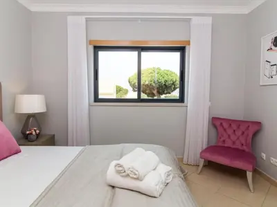 a bedroom with a bed and a window and a chair at Magnólia O House by Stay ici Algarve Holiday Rental in Albufeira