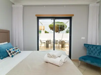 a bedroom with a bed and a blue chair at Magnólia O House by Stay ici Algarve Holiday Rental in Albufeira