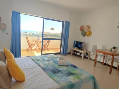 a bedroom with a bed and a balcony with a table at Endless Summer in Albufeira