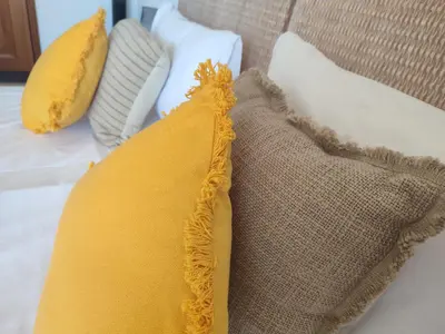 a yellow pillow sitting on a couch with pillows at Endless Summer in Albufeira