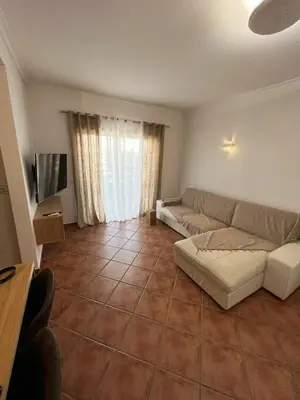 a living room with a couch and a television at Parra Home Holidays - Close to Galé Beach in Guia