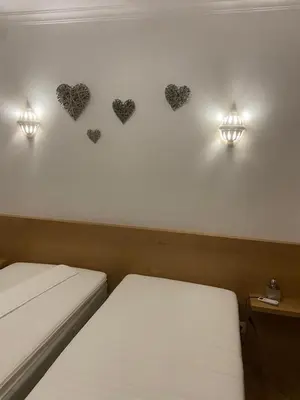 a room with two beds and hearts on the wall at Parra Home Holidays - Close to Galé Beach in Guia