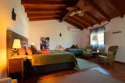 a bedroom with a bed and a living room at Cosy Farmhouse Quinta da Eira 140 years old in Loulé