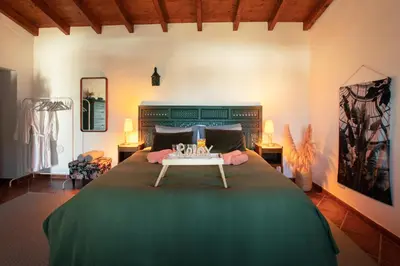 a bedroom with a large bed with a table on it at Cosy Farmhouse Quinta da Eira 140 years old in Loulé