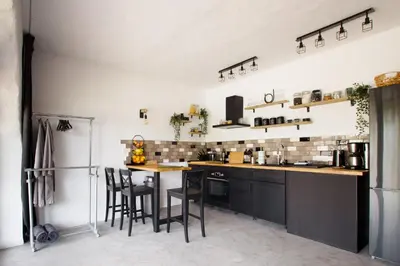 a kitchen with black cabinets and a table and chairs at Suite Swimming Pool Quinta da Eira 140 years old in Loulé