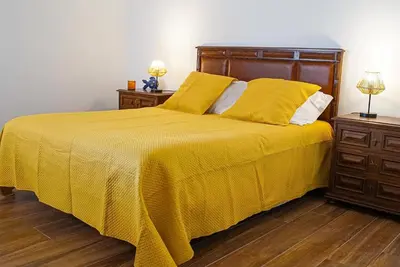 a bed with a yellow blanket and two night stands at One Bedroom Apartment Marina View in Albufeira