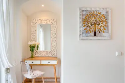 a hallway with a mirror and a table with a chair at Casa Perola - Vale do Garrão in Almancil