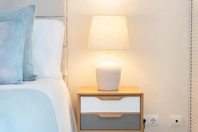 a lamp on a night stand next to a bed at Casa Perola - Vale do Garrão in Almancil