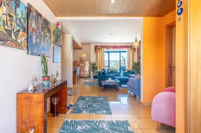 a living room with a blue couch and a room at Lovely LM Penthouse in Albufeira
