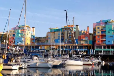 a group of boats docked in a harbor with buildings at Joyful Marina - Albufeira in Albufeira