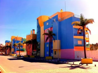 a colorful building with palm trees in front of it at Joyful Marina - Albufeira in Albufeira