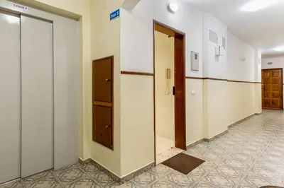 an empty hallway with two doors and a room with tiles at 1BR Infante Flat in Quarteira by LovelyStay in Quarteira