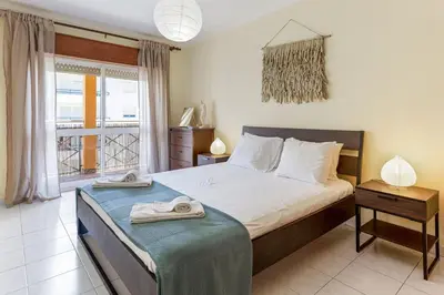 a bedroom with a large bed and a window at 1BR Infante Flat in Quarteira by LovelyStay in Quarteira