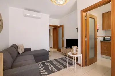a living room with a couch and a tv at Ae Flat Falesia in Albufeira