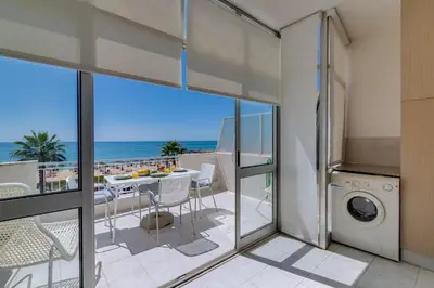 a kitchen with a balcony with a view of the ocean at AL - Oceano T2 Frente Mar Quarteira in Quarteira