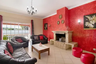 a living room with red walls and a fireplace at Villa Paraíso in Olhos de Água