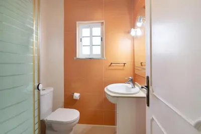 a small bathroom with a toilet and a sink at Villa Paraíso in Olhos de Água