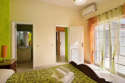 a bedroom with a bed and a large window at Villa Paraíso in Olhos de Água