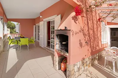 a patio with a fireplace and a table and chairs at Villa Paraíso in Olhos de Água