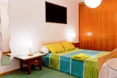 a bedroom with a bed and a tv on the wall at Coloured Studio in Faro