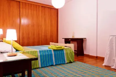 a bedroom with a bed with a desk and a table at Coloured Studio in Faro