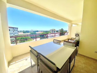 a balcony with a table and chairs and a large window at Vilamoura Avelãs Ocean View Apartment in Vilamoura