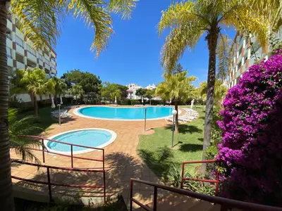 a resort with a swimming pool and palm trees at Vilamoura Avelãs Ocean View Apartment in Vilamoura