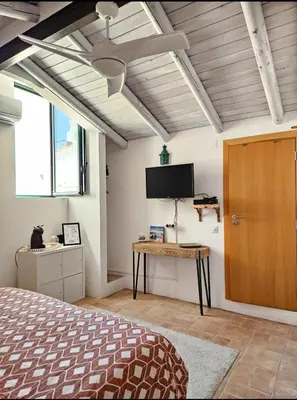 a bedroom with a bed and a flat screen tv at Casa Aventura in Boliqueime