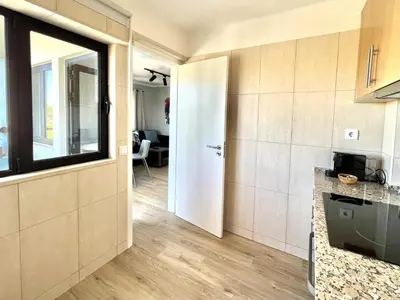 a kitchen with a door leading to a living room at Porto Marina - City center by HD PROPERTIES in Vilamoura