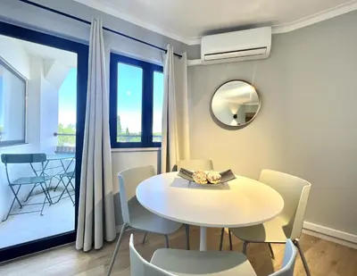 a dining room with a table and chairs and a mirror at Porto Marina - City center by HD PROPERTIES in Vilamoura