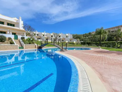 a large swimming pool in front of a building at Cozy Townhouse Vila Rafaella2 near São Rafael Beach Albufeira in Albufeira