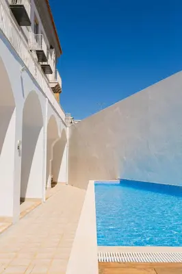 a swimming pool next to a white building at Algarve Sweetness Apartment in Faro