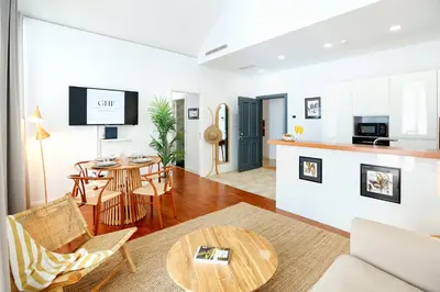 a living room with a table and a kitchen at Algarve Sweetness Apartment in Faro