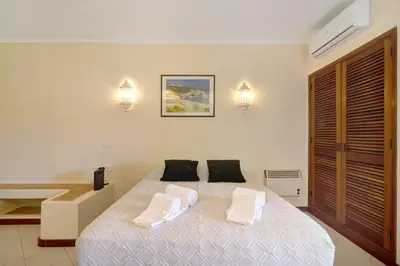 a bedroom with a bed with two pillows and a sink at Belavista House in Albufeira
