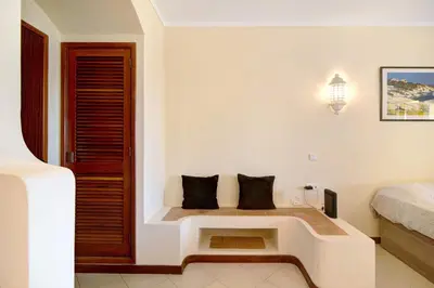 a bedroom with a bed and a bench with two pillows at Belavista House in Albufeira