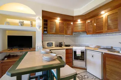 a living room with a couch and a table and a kitchen at Belavista House in Albufeira