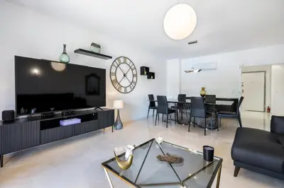 a living room with a large tv and a table at Love Nest Algarve Edition vilamoura in Vilamoura