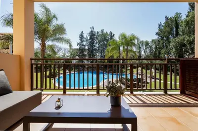 a patio with a table and a chair and a pool at Love Nest Algarve Edition vilamoura in Vilamoura
