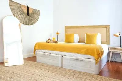 a bedroom with a large bed with a yellow blanket at Beach Waves Apartment in Faro